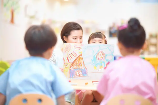 子どもたちと紙芝居をする女性