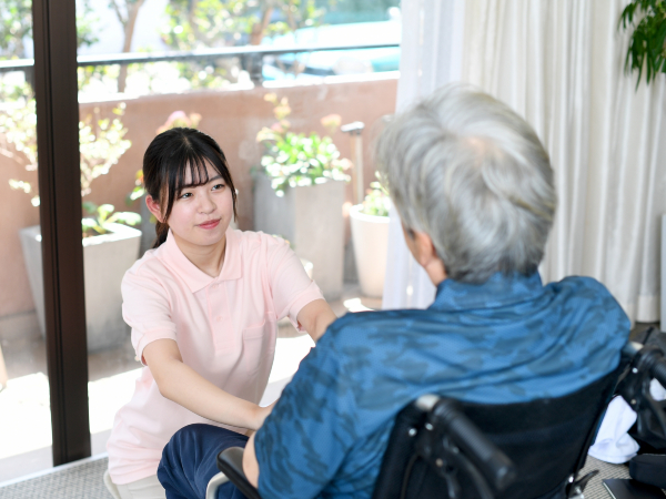 車椅子の男性を介護する女性介護士