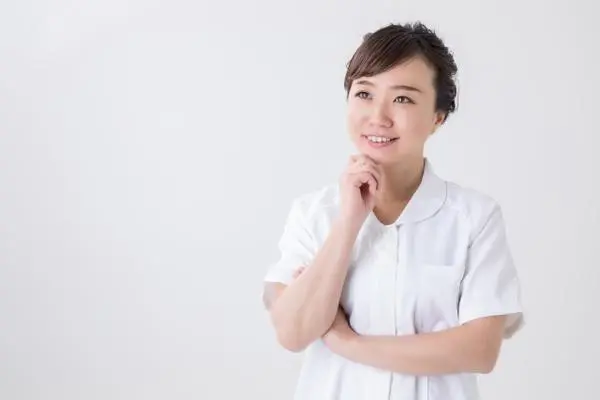 笑顔であごに手を当てる女性看護師