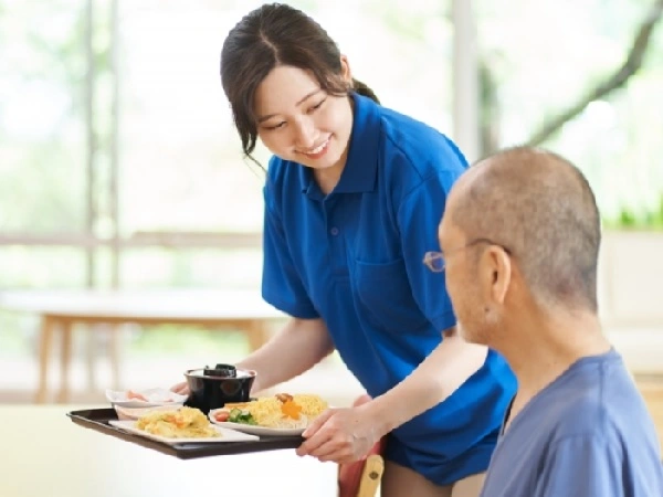 食事を手に微笑みかける女性